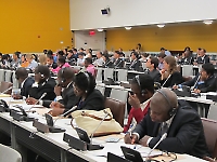 Delegates listening to the briefing and taking notes