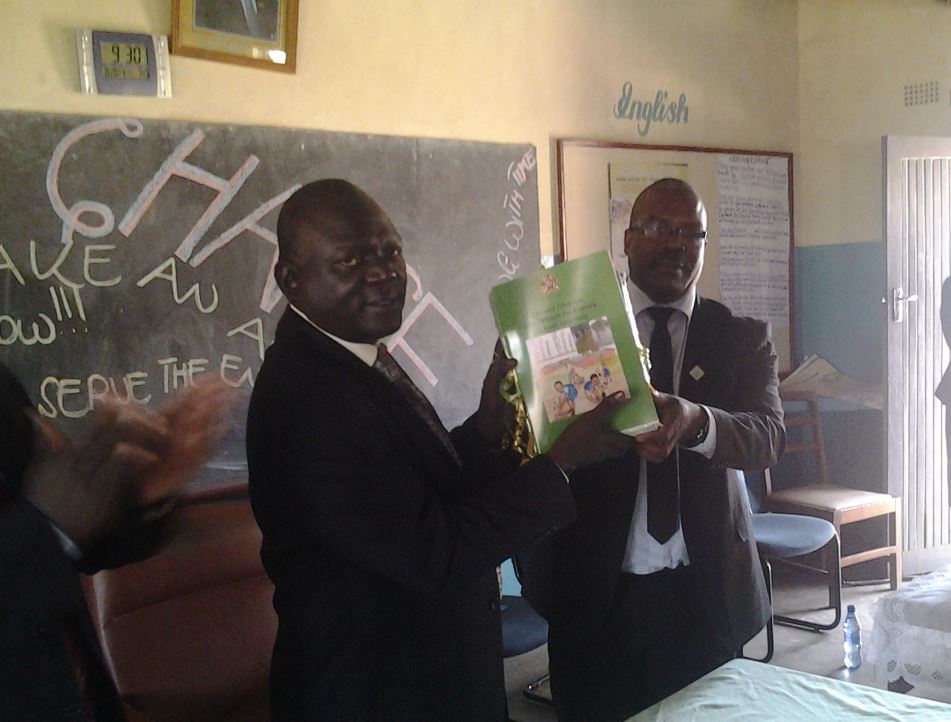 Deputy Minister of Education, Science and Technology, Vincent Ghambi launching the resource book