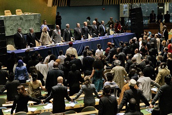 Participants in a United Nations meeting hold hands in unity