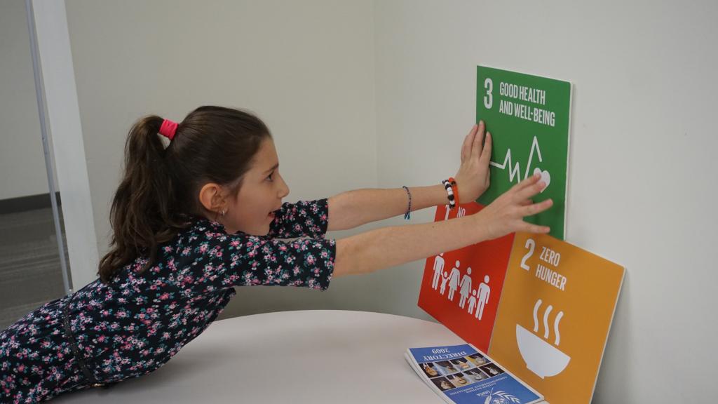 A participant posts signs describing the first three SDGs