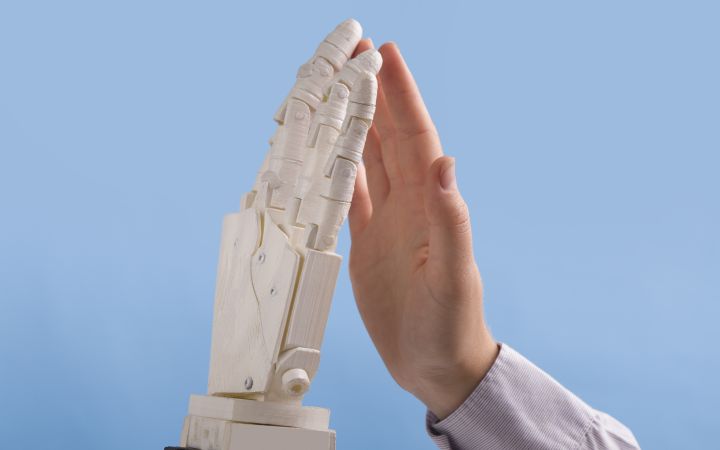 Defending Human Rights in the Age of Artificial Intelligence Human and robot hands high five