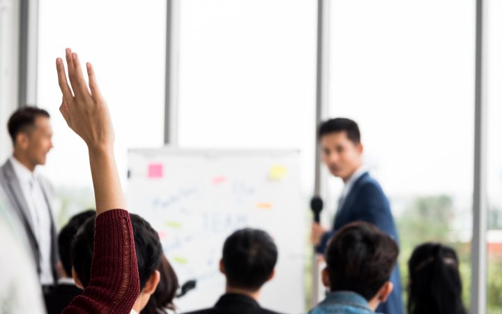 Training of Trainers (Photo via Envato Elements) Participant raising his/her hand during a conference