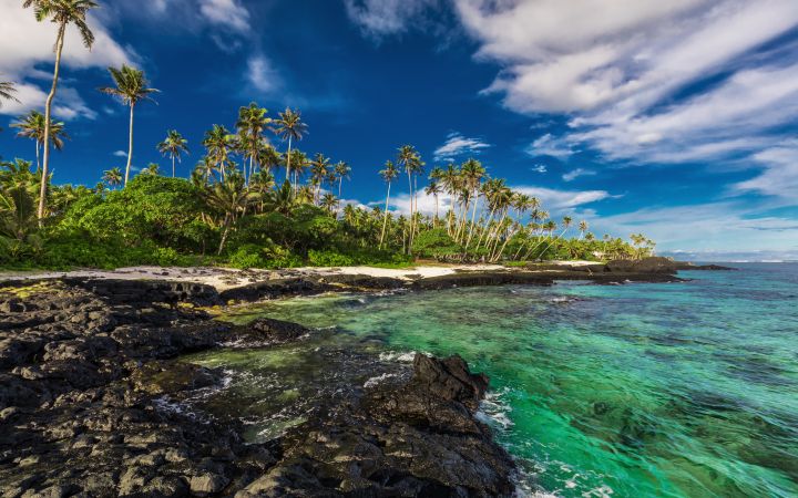 Beach with coral reef and black volcanic rocks on south side of Upolu, Samoa Islands