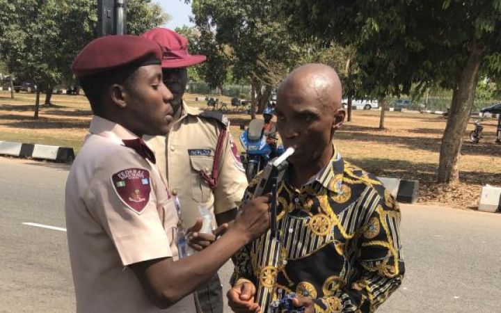 Official from the Federal Road Safety Corps conducting a breathalyzer test Official from the Federal Road Safety Corps conducting a breathalyzer test
