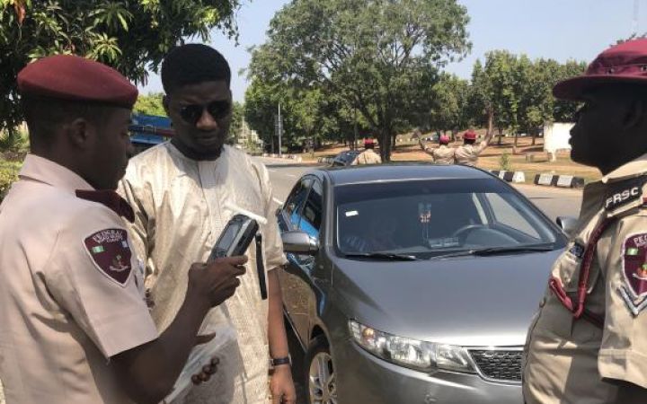 Official from the Federal Road Safety Corps conducting breathalyzer test.