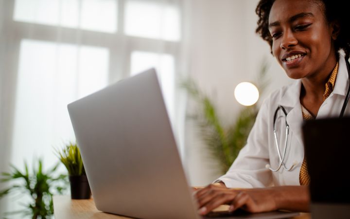 A female doctor is typing on her laptop