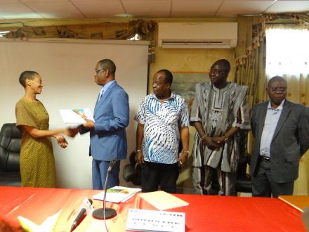 Mrs. Metsi Makhetha, United Nations Resident Coordinator in Burkina Faso congratulates Mr. Nestor Batio Bassiere, Minister of Environment, Green Economy and Climate Change, next to representatives from Ministries of Health, Education and Agriculture.